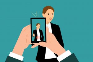 Cartoonish illustration of someone using a smartphone to take a photograph of a woman wearing a business suit. 